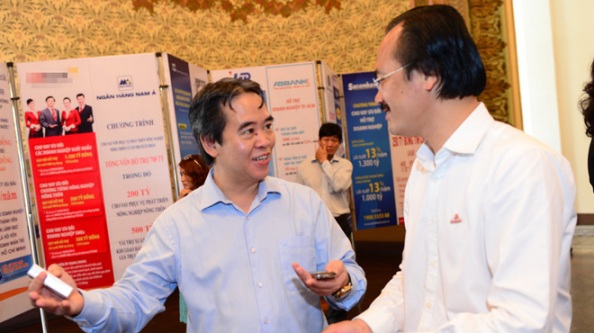 Thống đốc Ngân hàng Nhà nước VN Nguyễn Văn Bình (trái) trao đổi với doanh nhân bên lề hội nghị “Kết nối ngân hàng - doanh nghiệp tháo gỡ khó khăn” ngày 28-7 tại TP.HCM