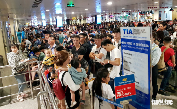 Máy bay liên tục hoãn chuyến, hành khách nằm, ngồi la liệt ở Tân Sơn Nhất - Ảnh 2.