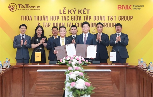 Ông Đỗ Quang Hiển, Chủ tịch UBCL Tập đoàn T&amp;T (bên trái) và ông Bin Dae-in, Chủ tịch HĐQT kiêm TGĐ Tập đoàn Tài chính BNK (bên phải) trao thỏa thuận hợp tác với sự chứng kiến của đại diện lãnh đạo hai Tập đoàn. Nguồn ảnh: T&amp;T Group