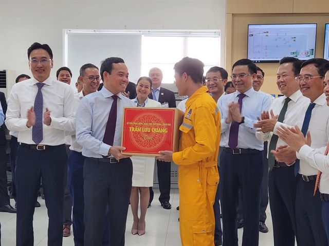 Phó Thủ tướng Trần Lưu Quang tặng quà cho đội ngũ kỹ sư vận hành kho LNG 1 MMTPA Thị Vải. Ảnh: TK