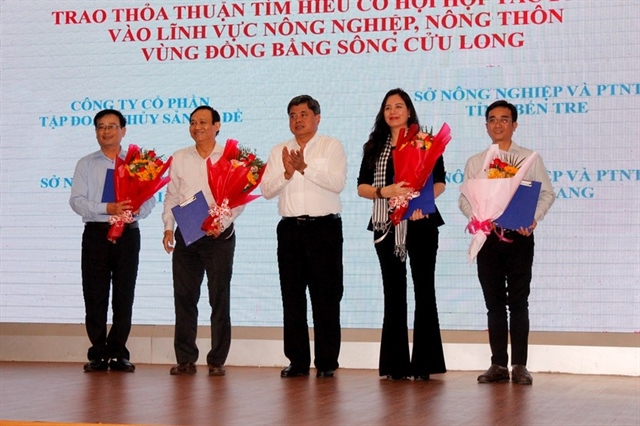 Thứ trưởng Trần Thanh Nam tặng hoa cho các tỉnh và doanh nghiệp trao thỏa thuận tìm hiểu cơ hội hợp tác đầu tư vào lĩnh vực nông nghiệp, nông thôn vùng ĐBSCL. Ảnh: NHẪN NAM