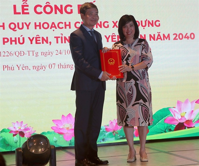 Đại diện Bộ Xây dựng (bên phải) trao quyết định điều chỉnh quy hoạch chung xây dựng KKT Nam Phú Yên cho chủ tịch UBND tỉnh Phú Yên. Ảnh: VŨ XUÂN