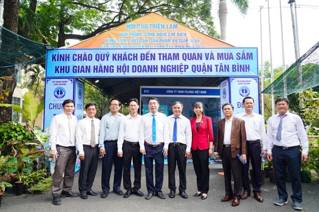 Phó Chủ tịch UBND quận Tân Bình tham quan gian hàng của các doanh nghiệp. ẢNH: TÚ UYÊN