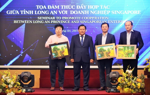 Ông Huỳnh Văn Sơn, Phó Chủ tịch UBND tỉnh Long An trao quà lưu niệm cho các đại biểu Singapore. Ảnh: HUỲNH DU