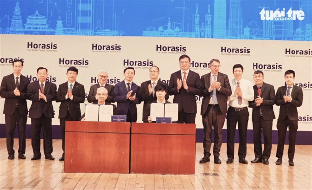 Deputy Prime Minister Tran Hong Ha (standing, 5th, left), officials from Binh Duong Province and guests witness the signing of a cooperation agreement between a Vietnamese firm and a Chinese company. Photo: Ba Son / Tuoi Tre