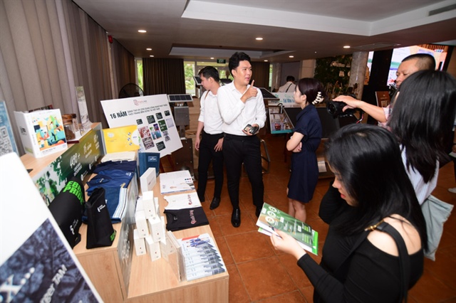 An attendee explores an exhibition stall hosted by Tuoi Tre (Youth) newspaper at the ‘Carbon Credit Market - A Driver for Building a Green Vietnam’ conference held at the Van Thanh Tourism Area in Binh Thanh District, Ho Chi Minh City on April 20, 2024. Photo: Quang Dinh / Tuoi Tre