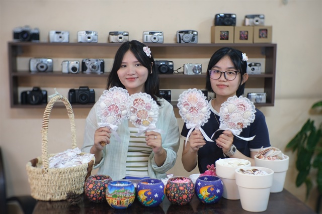 Nguyen Ngoc Khanh Huyen (left) poses with Nguyen Pham Nha Tue who helps Huyen with customer care. Photo: Ngoc Phuong / Tuoi Tre News