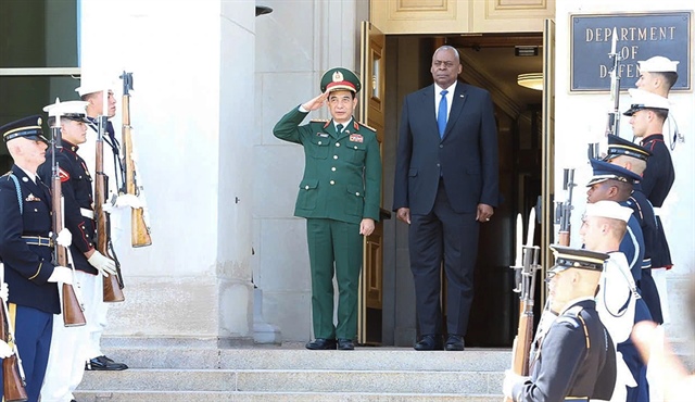 Vietnamese Minister of National Defense General Phan Van Giang (L) and U.S. Secretary of Defense Lloyd Austin (C) hand over war keepsakes to each other after their talks in Washington, D.C., September 9, 2024. Photo: mod.gov.vn