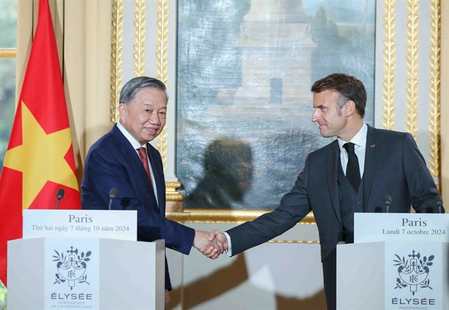 The exchange of an education cooperation agreement between the Vietnamese and French representatives in the presence of Vietnamese Party General Secretary and State President To Lam (L) and French President Emmanuel Macron in Paris, France on October 7, 2024. Photo: Nguyen Hong / Tuoi Tre