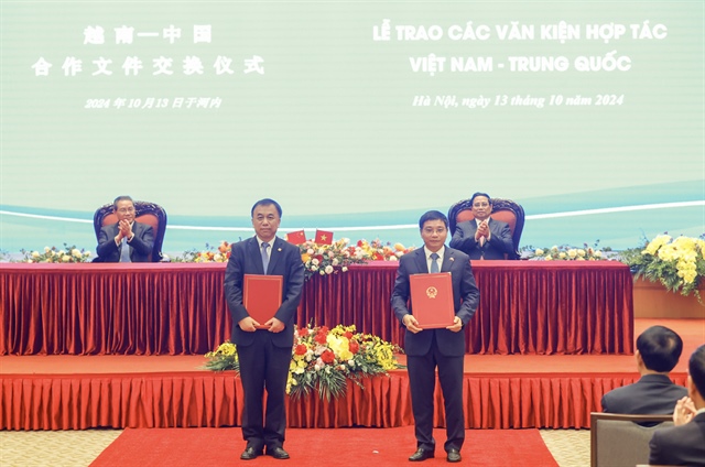 Vietnamese Prime Minister Pham Minh Chinh (sitting, back row, right) and Chinese Prime Minister Li Qiang (sitting, back row, left) witness the exchange of a memorandum of understanding on technical solutions to the connection of railway stations between Vietnam and China in Hanoi on October 13, 2024. Photo: Doan Bac