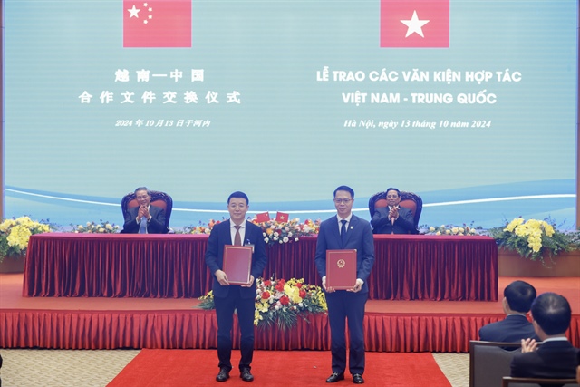 Vietnamese Prime Minister Pham Minh Chinh (sitting, back row, right) and Chinese Prime Minister Li Qiang (sitting, back row, left) witness the exchange of an MoU on the launch of Vietnam-China cross-border payment services via QR codes in Hanoi on October 13, 2024. Photo: Doan Bac