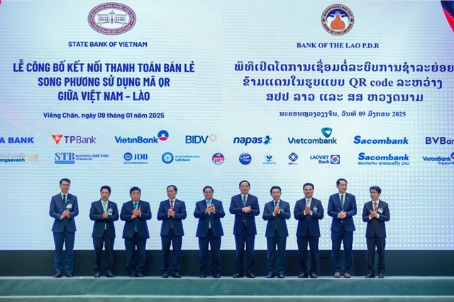 Prime Minister Pham Minh Chinh (5th, left) and Laotian Prime Minister Sonexay Siphandone (5th, right) at a ceremony to launch the framework for bilateral retail payments using QR codes between Vietnam and Laos in Laos on January 9, 2024. Photo: Doan Bac