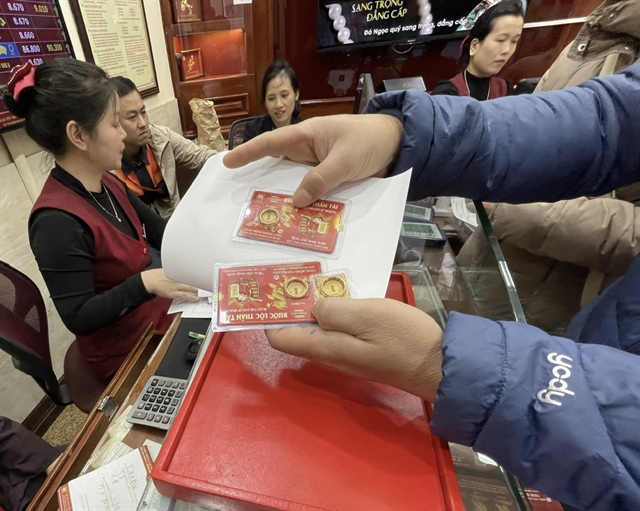 A customer buys gold rings at a Bao Tin Minh Chau shop in Hanoi. Photo: Le Thanh / Tuoi Tre