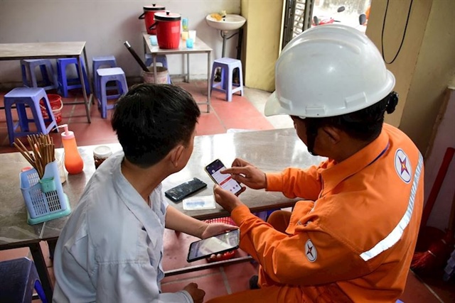 Nhân viên công ty điện lực Hà Nội hướng dẫn khách hàng nắm các thông tin chính xác về điện. Ảnh: EVNHANOI