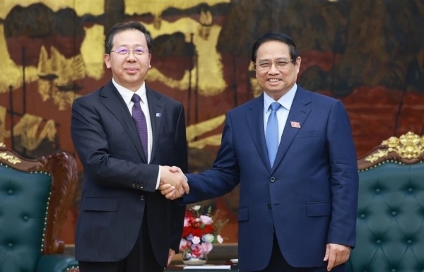 Prime Minister Pham Minh Chinh (R) receives Peng Gangping, Chairman of China Huadian Engineering Co., Ltd. (Photo: VNA)