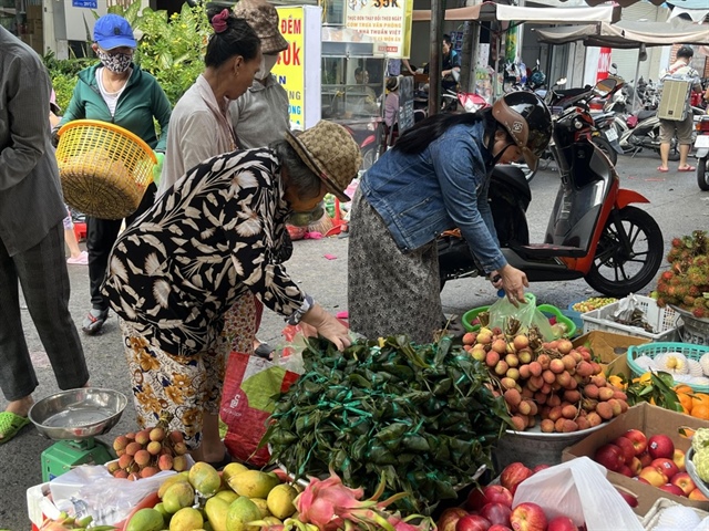 Người dân mua sớm bánh ú tro, trái cây trong sáng ngày mùng 4.