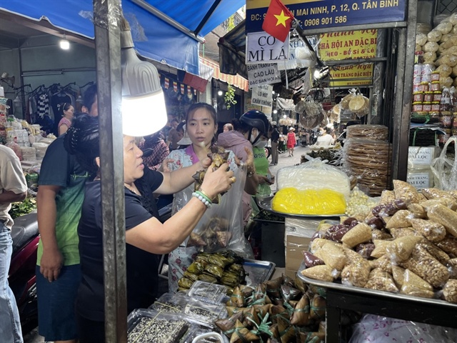 Tiểu thương không ngớt tay bán bánh ú tro trong sáng ngày mùng 5.