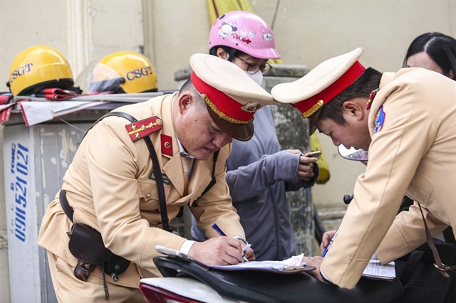 Lực lượng công an lập biên bản xử phạt các hành vi vi phạm giao thông. Ảnh: P.HÙNG