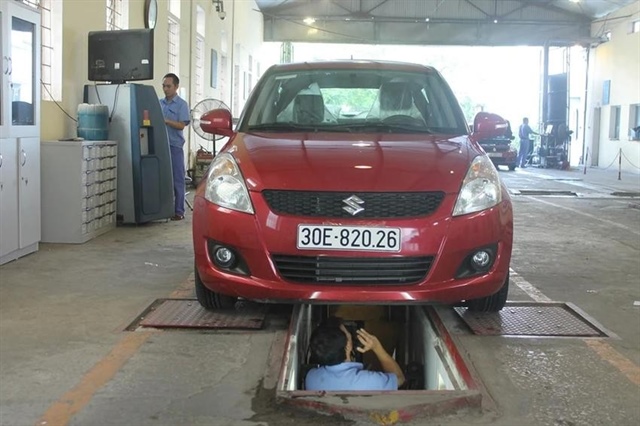 Nhân viên đăng kiểm thực hiện kiểm định phương tiện. Ảnh: V.LONG