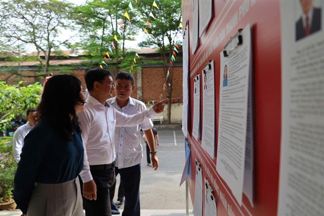 Ông Nguyễn Mạnh Cường kiểm tra bảng thông tin danh sách người ứng cử. Ảnh: THANH THÙY