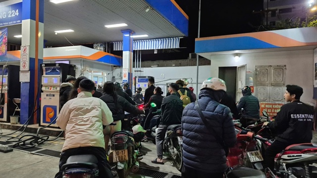 Người dân chờ đến lượt đổ xăng tối 9-3 tại Hà Nội. Ảnh: AH