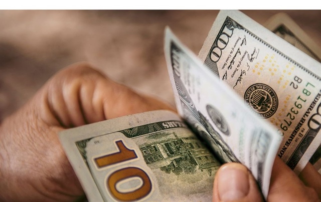 Giá đôla Mỹ tại các ngân hàng được niêm yết ở mức kịch trần, trong khi USD trên thị trường tự do đã vượt mốc 27.000 đồng/USD. Ảnh minh họa