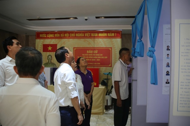 Lãnh đạo TP.HCM kiểm tra khu vực niêm yết danh sách cử tri, ánh sáng... tại điểm bỏ phiếu chung cư Opal, phường Dĩ An. Ảnh: PHẠM HẢI