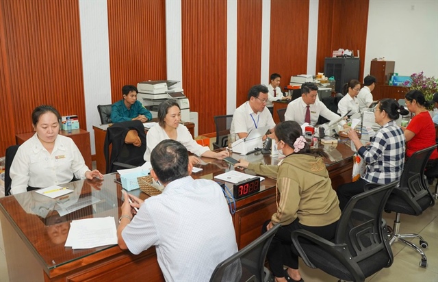 Cán bộ ở TP.HCM hướng dẫn người dân làm thủ tục hành chính. Ảnh: PHẠM HẢI