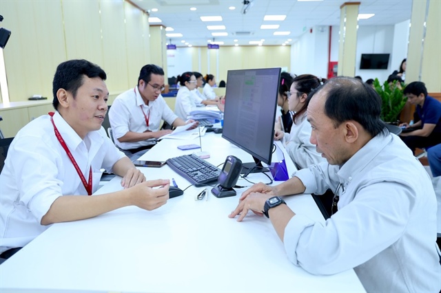 Cán bộ tại Trung tâm Phục vụ Hành chính công TP.HCM tiếp nhận hồ sơ. Ảnh: LÊ THOA