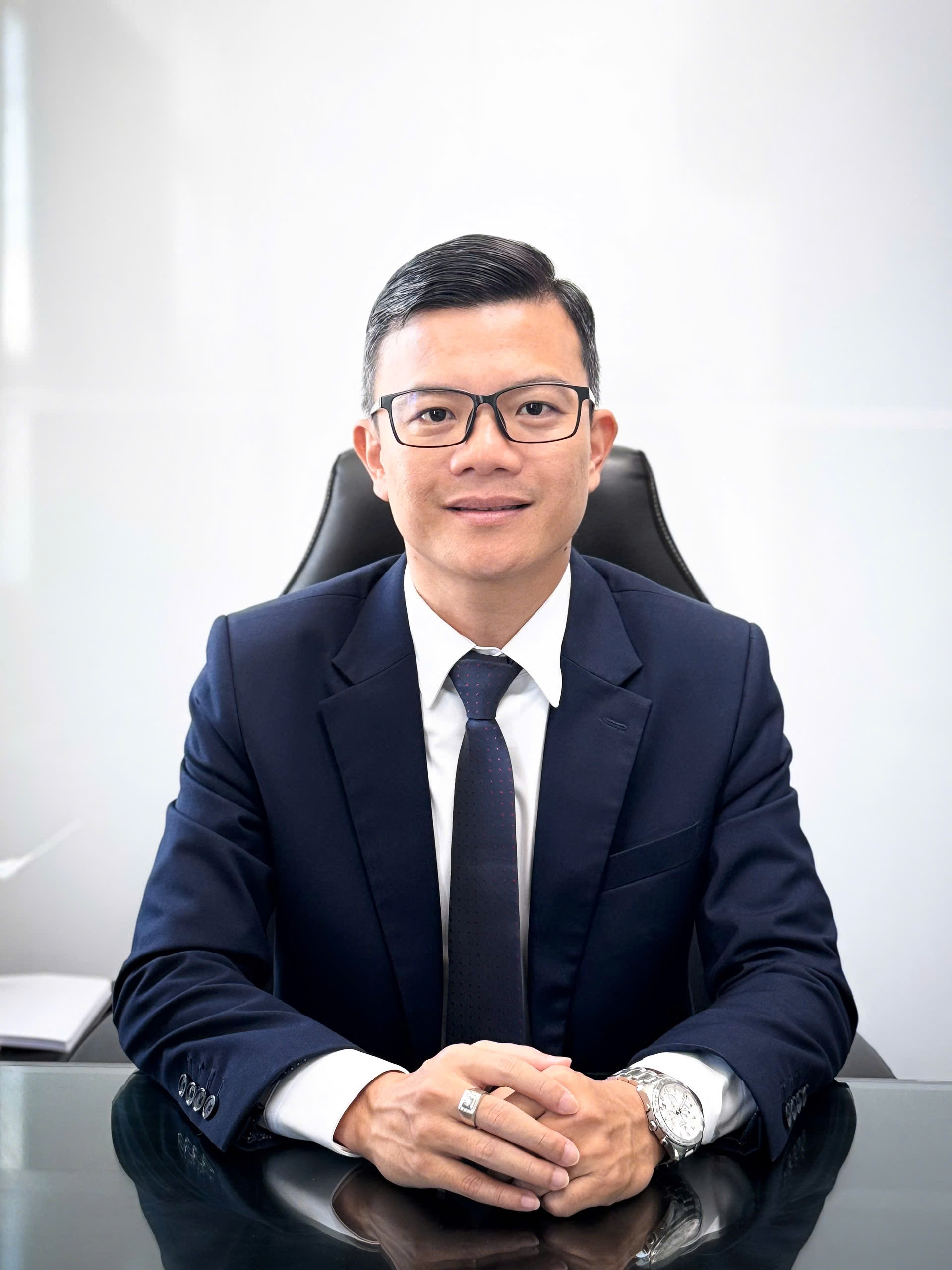 Ông Hồ Đức Toàn trong bộ vest tại bàn làm việc